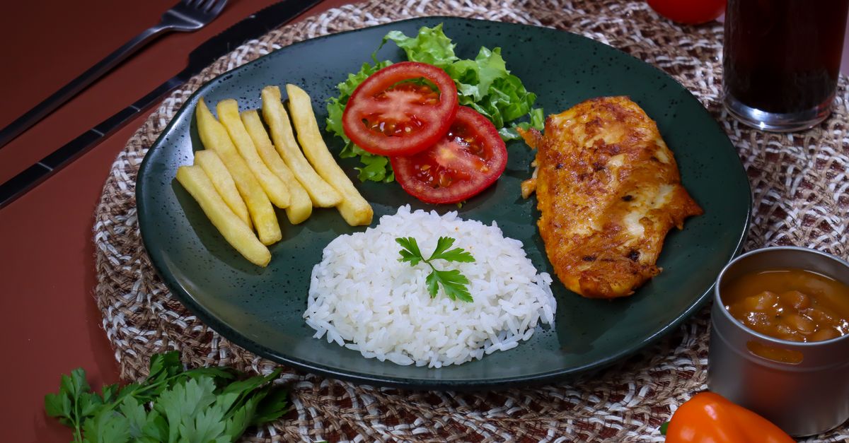A vibrant plate of jollof rice with grilled chicken and salad at a church event