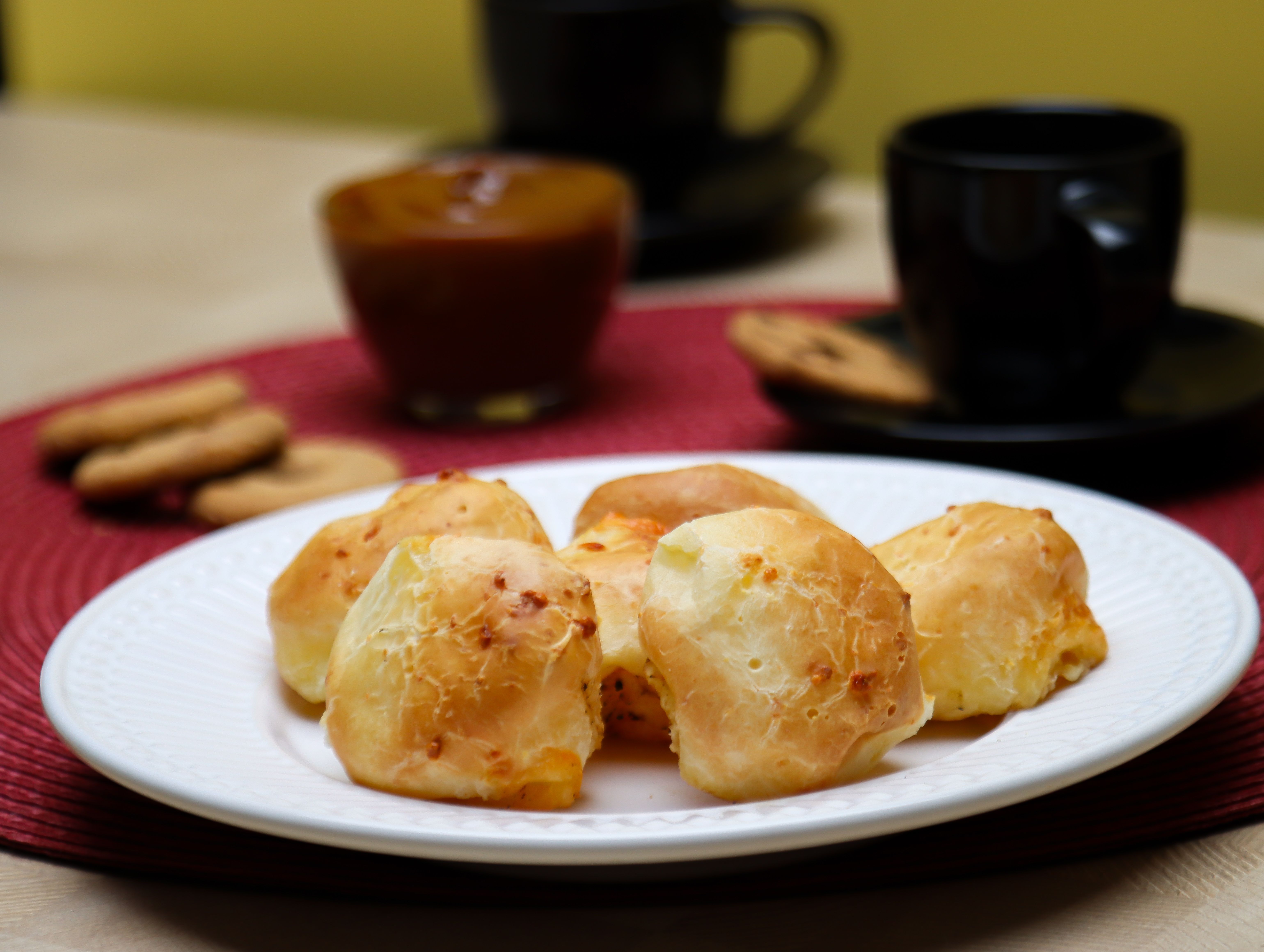 Appetizing cheese bread rolls served with coffee and cookies for a delightful snack.