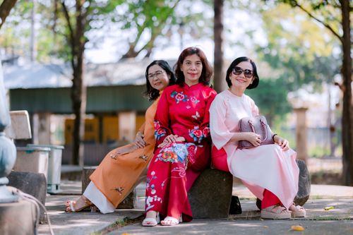 Free Three women in vibrant traditional dresses enjoying a sunny day outdoors. Stock Photo