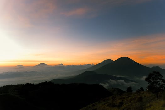 Stunning sunrise with vibrant colors over a misty mountain range, offering a serene and majestic view.