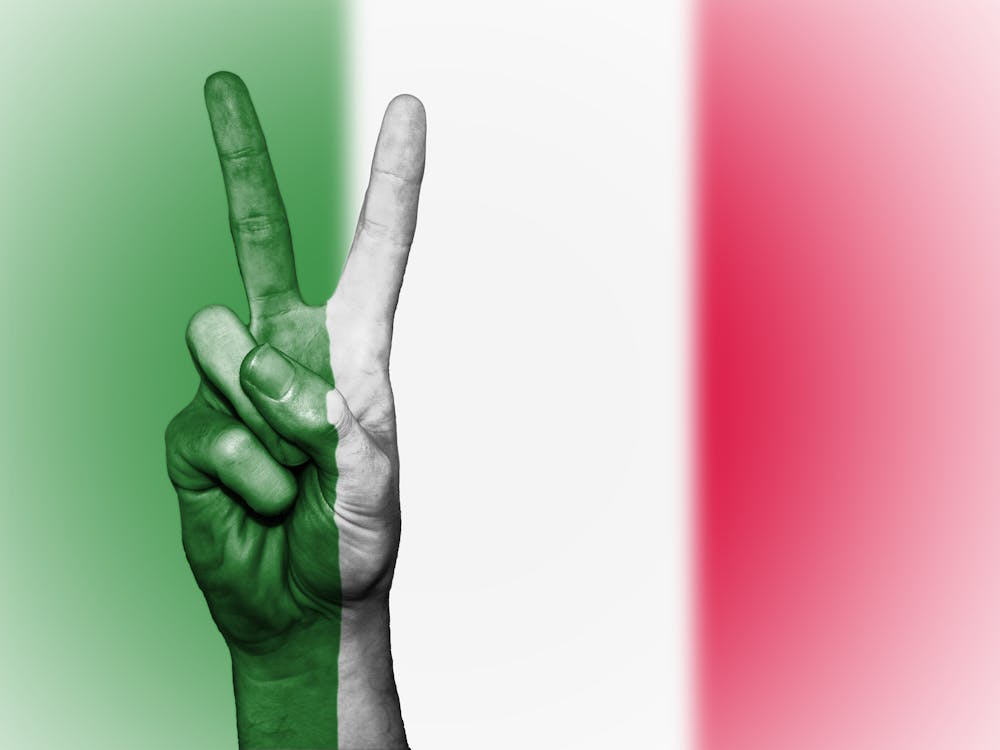 Free Person's Hand Doing Peace Sign With India Flag Backdrop Stock Photo