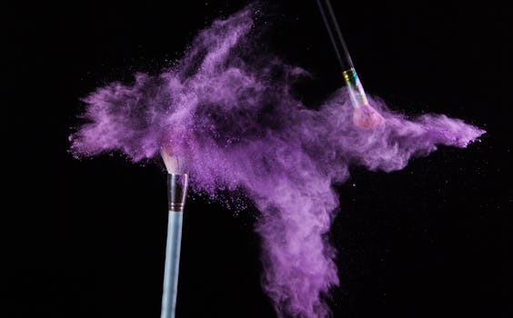 Purple makeup powder exploding in motion with brushes against a dark backdrop.