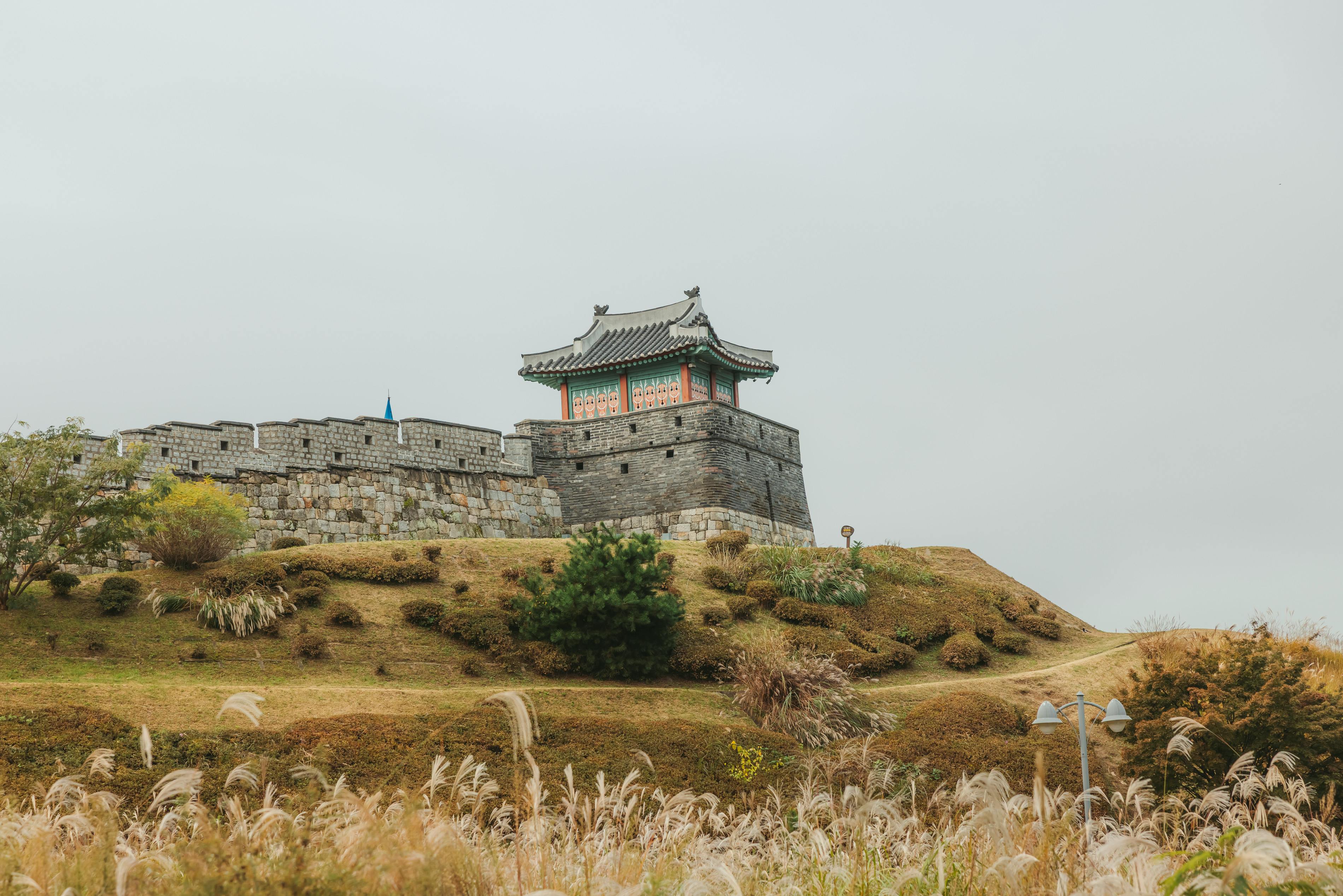 Scenic view of a historical Korean fortress surrounded by autumn foliage.