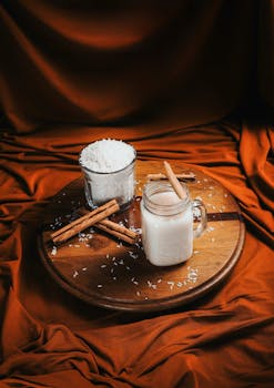 A cozy arrangement featuring a cinnamon-infused rice drink on a wooden platter, evoking a warm and comforting atmosphere.