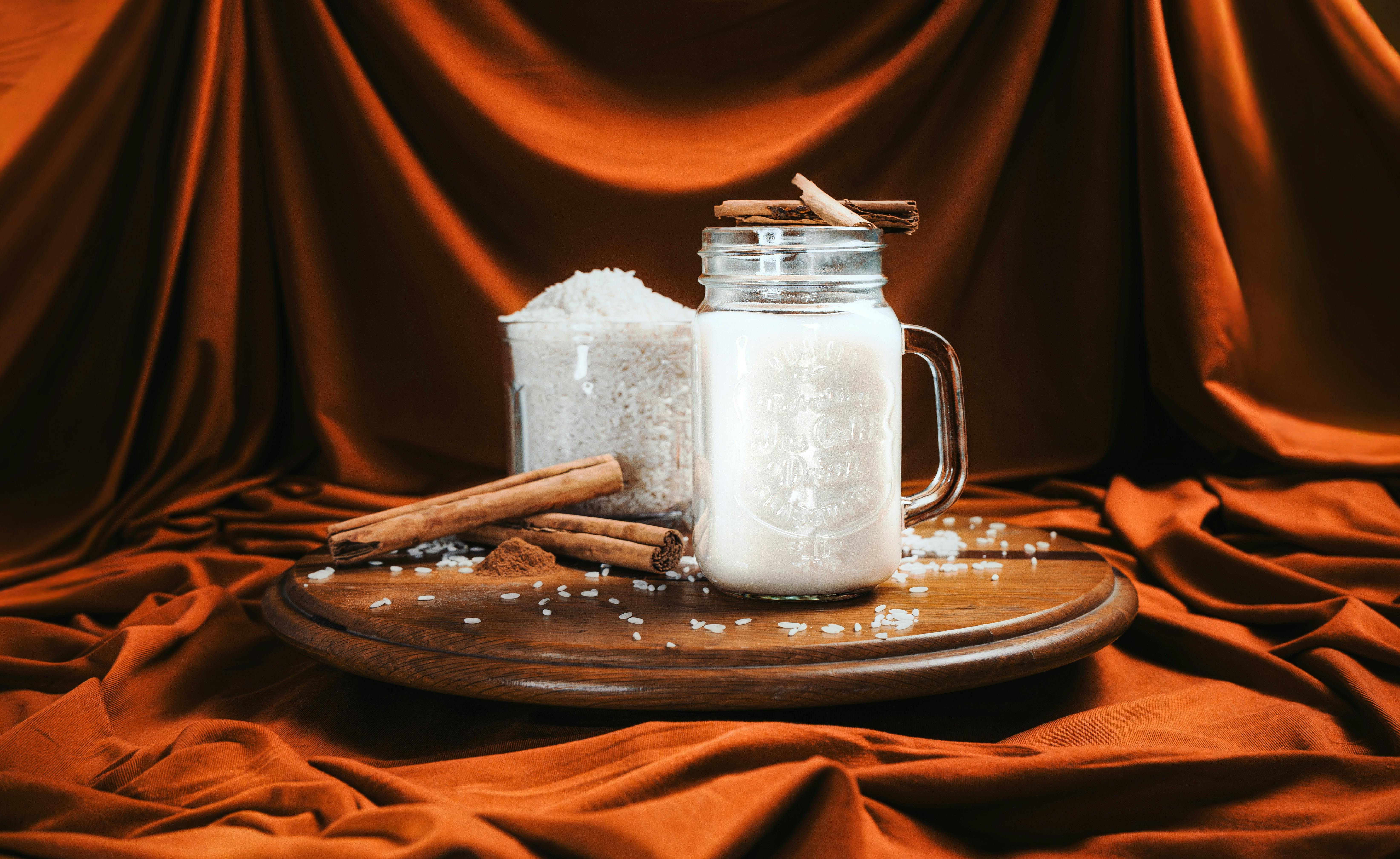 Inviting cinnamon-spiced rice milk in a jar with a cozy, rustic backdrop. Perfect for culinary themes.