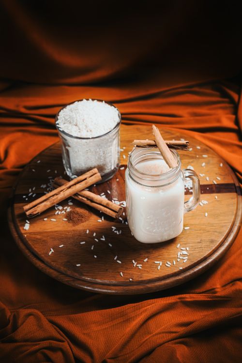 Free Cozy cinnamon-spiced rice beverage on a wooden platter with warm tones. Stock Photo