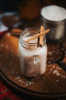 Warm cinnamon-flavored drink in a mason jar, perfect for a cozy setting.