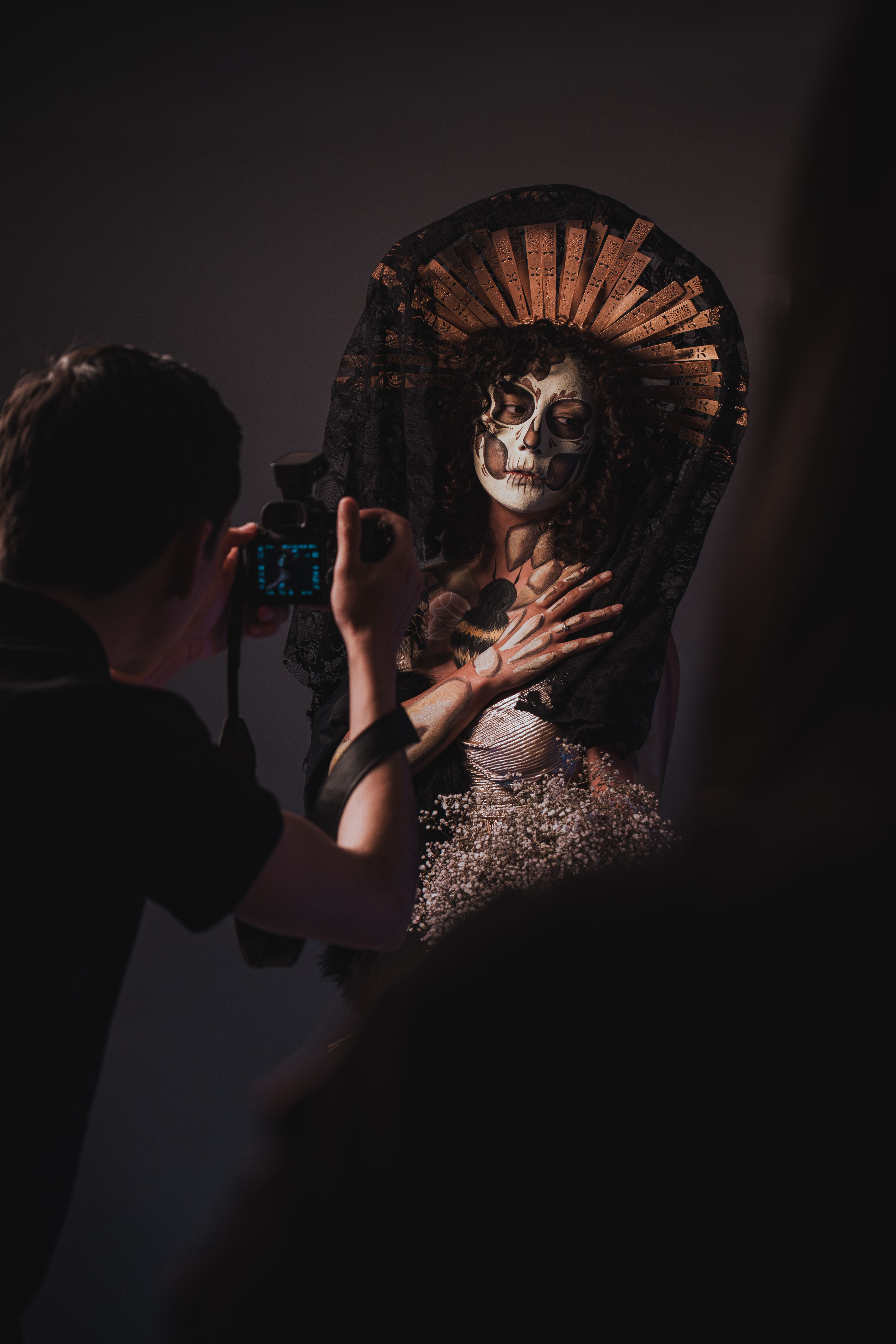 A photographer captures a model in Catrina makeup, embodying Día de Muertos art and tradition.