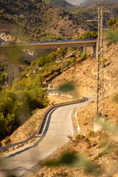 Winding road through mountains in Andalusia, Spain. Elevated view with lush greenery.