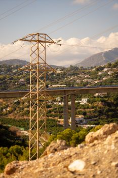 Electricity pylon stands tall amidst the picturesque landscape of Nerja, Andalusia.