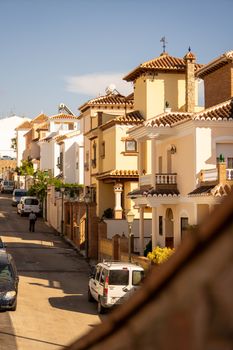 Sunny view of traditional Andalusian architecture on a quiet street in Nerja, Spain.