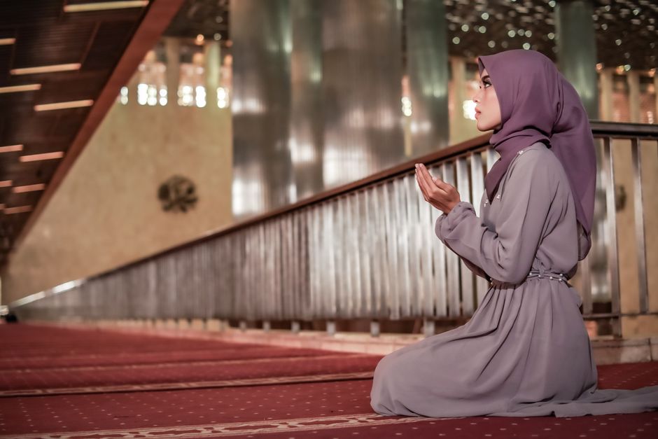 A woman in a hijab praying inside a mosque in Jakarta, emphasizing spirituality and peace.