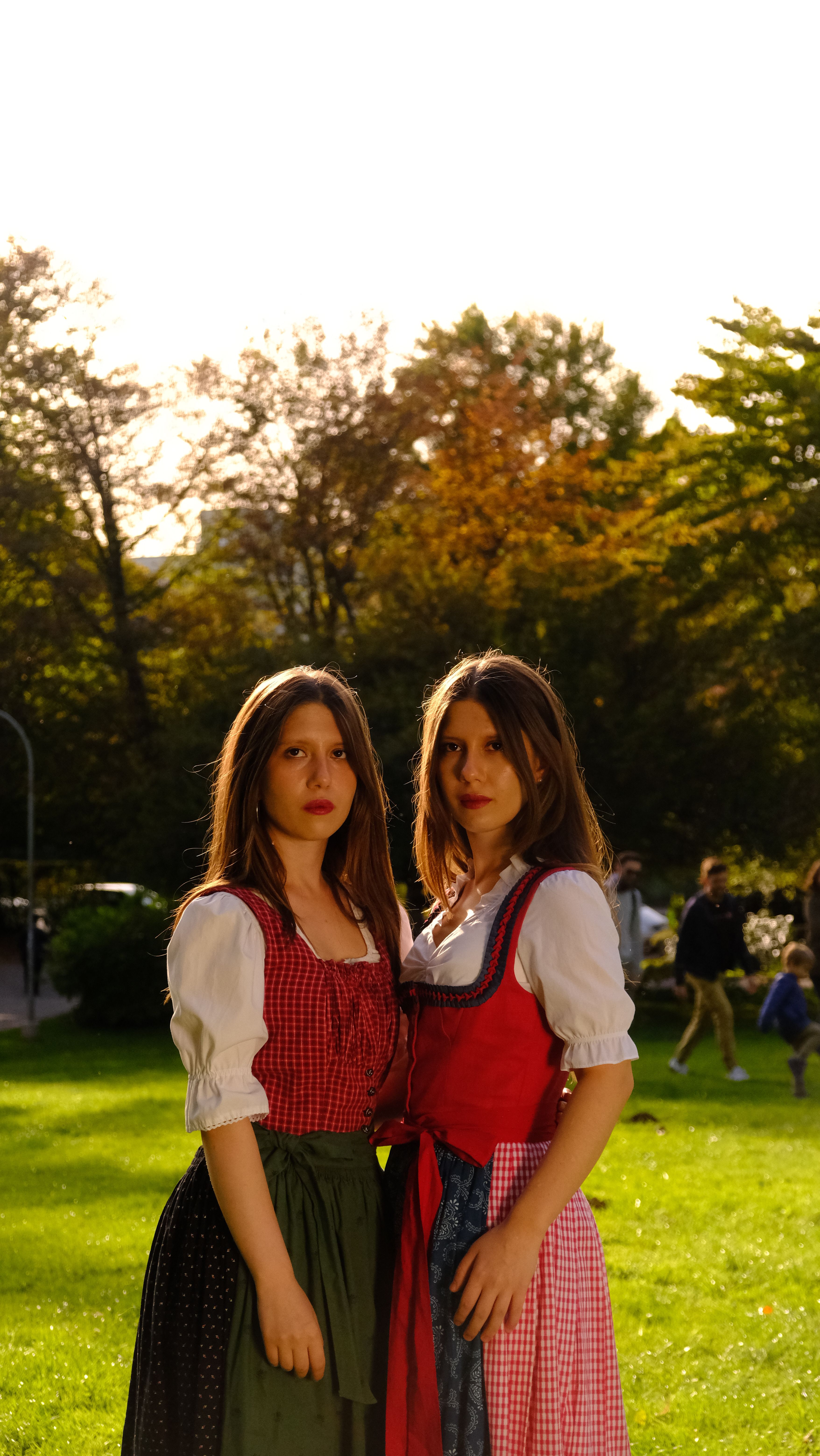Gratis To kvinner i tradisjonelle østerrikske kjoler poserer i en solfylt park i Graz, Østerrike. Arkivbilde