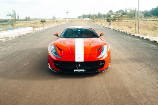 A striking red Ferrari 812 GTS captured on an open road in Mysuru, India.