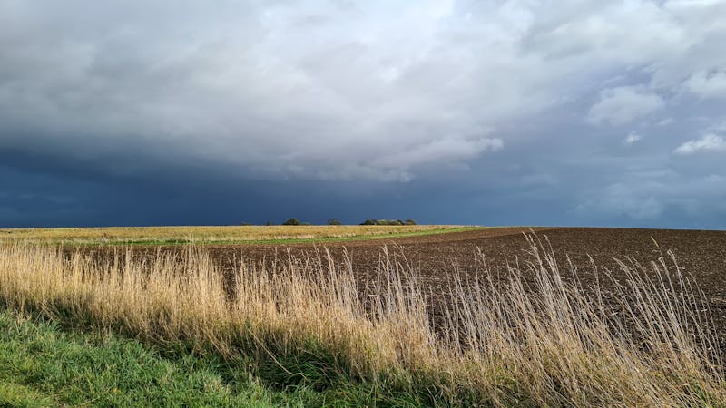 Stormachtige donkere lucht boven Limburgse akkers bij Sittard — dramatisch herfstweer in Nederland