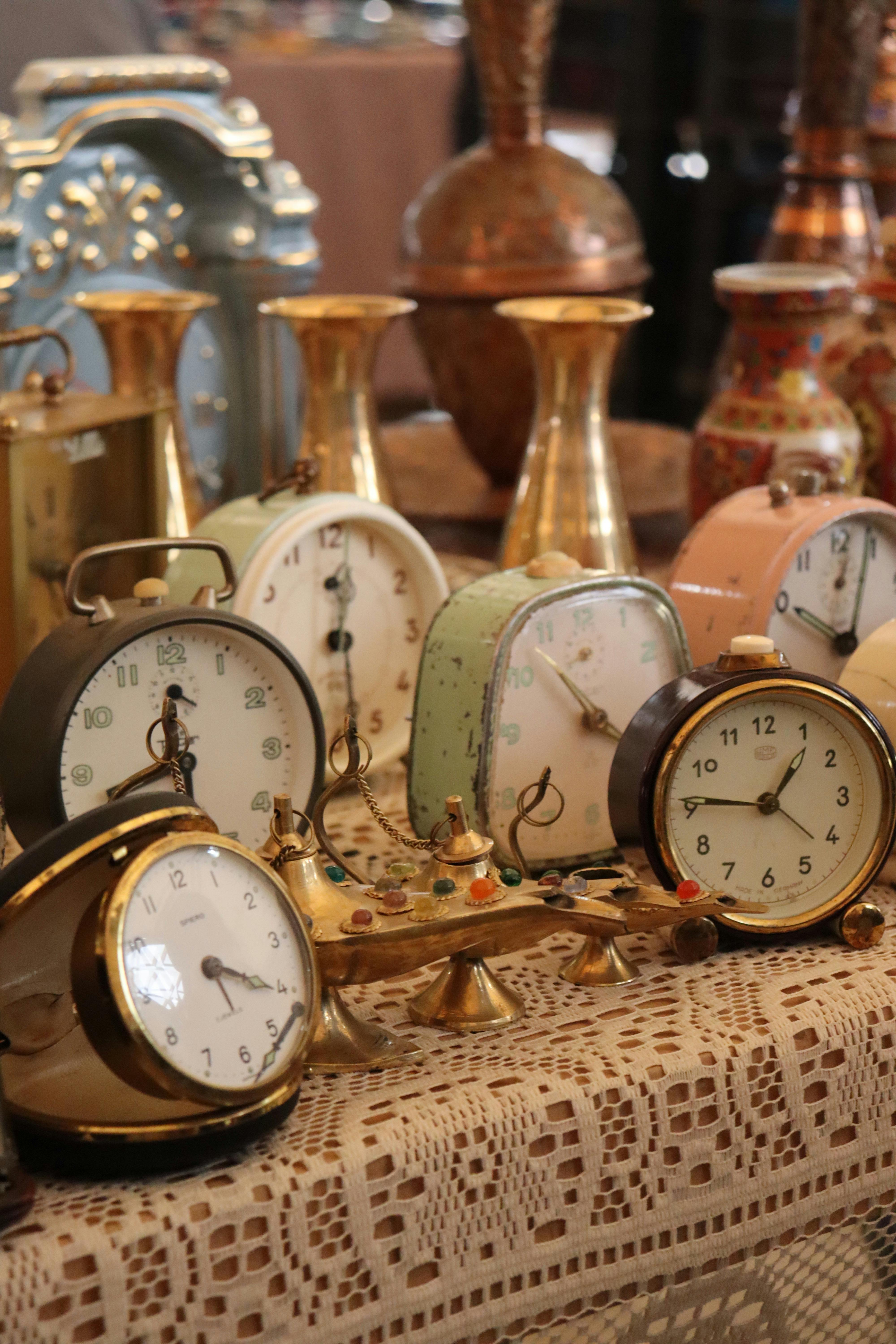 A collection of vintage alarm clocks showcased at an antique market, showcasing retro design.