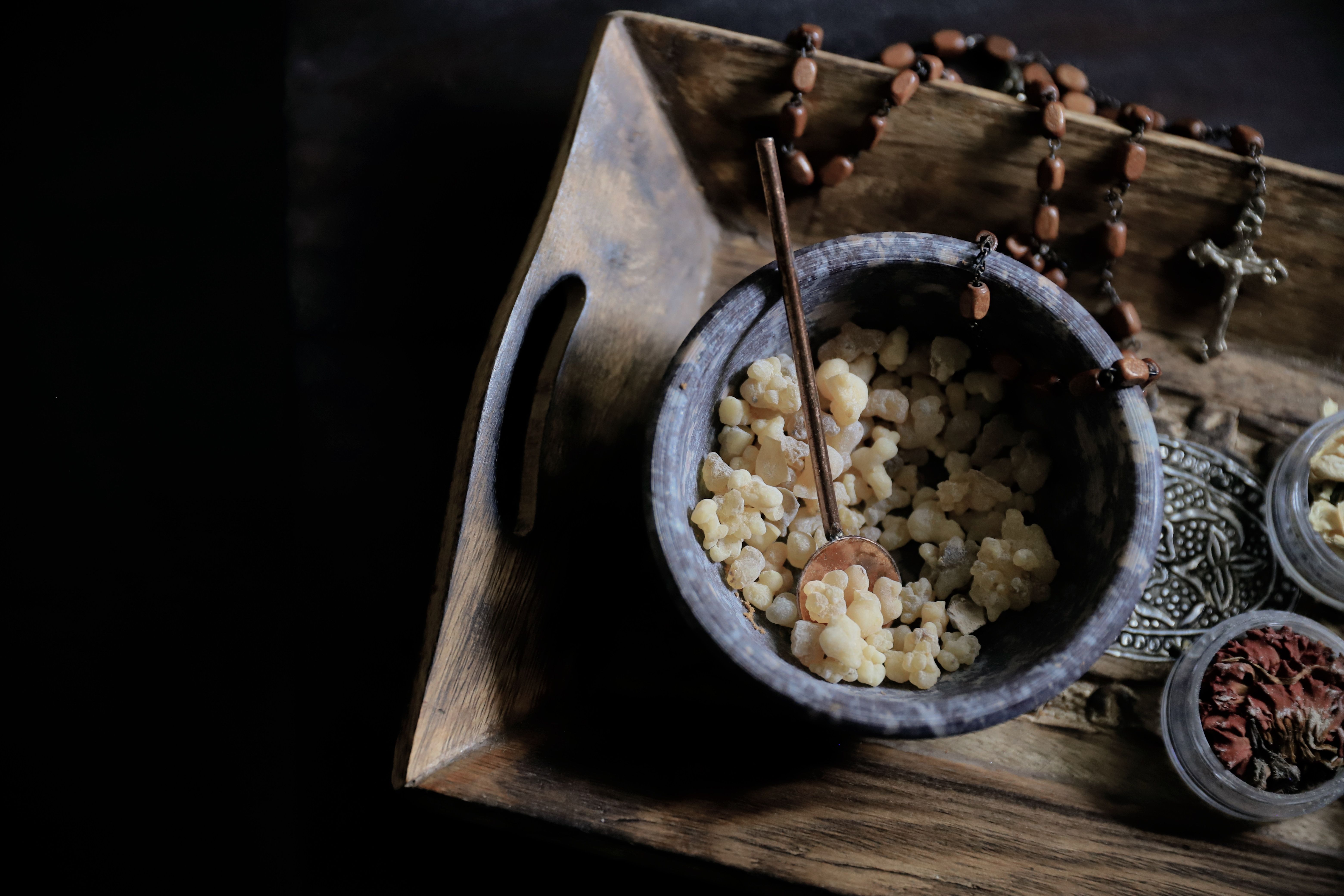 A collection of incense and religious items arranged artistically on a wooden tray, creating a peaceful ambiance.