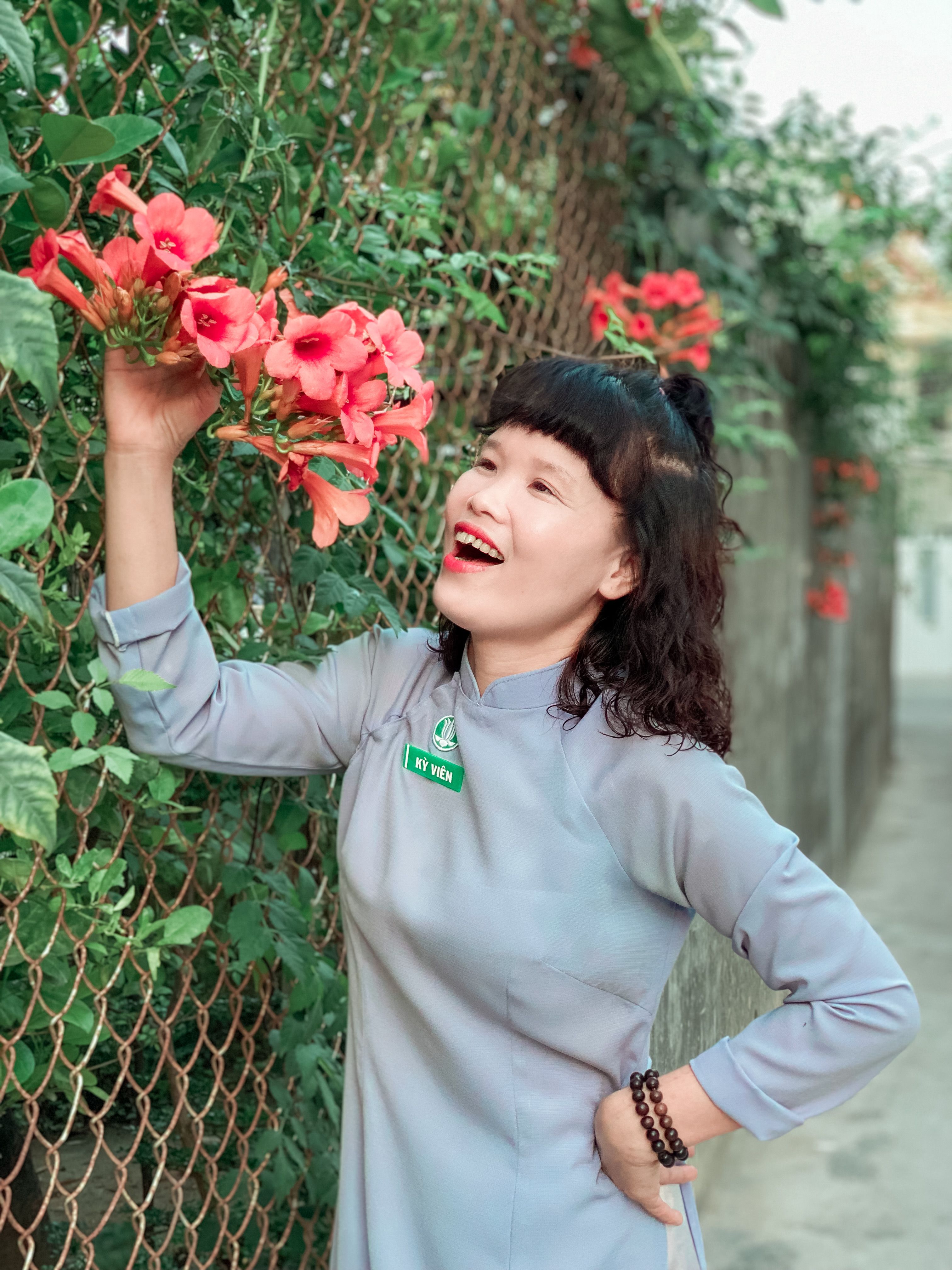 Woman Enjoying Bright Red Flowers Outdoors