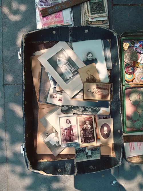 Free Collection of vintage photographs in an open suitcase, sunlight and shadows outdoors. Stock Photo
