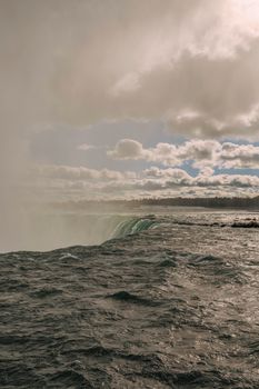 Captivating view of Niagara Falls under a dramatic sky in autumn. Perfect for travel and nature themes.