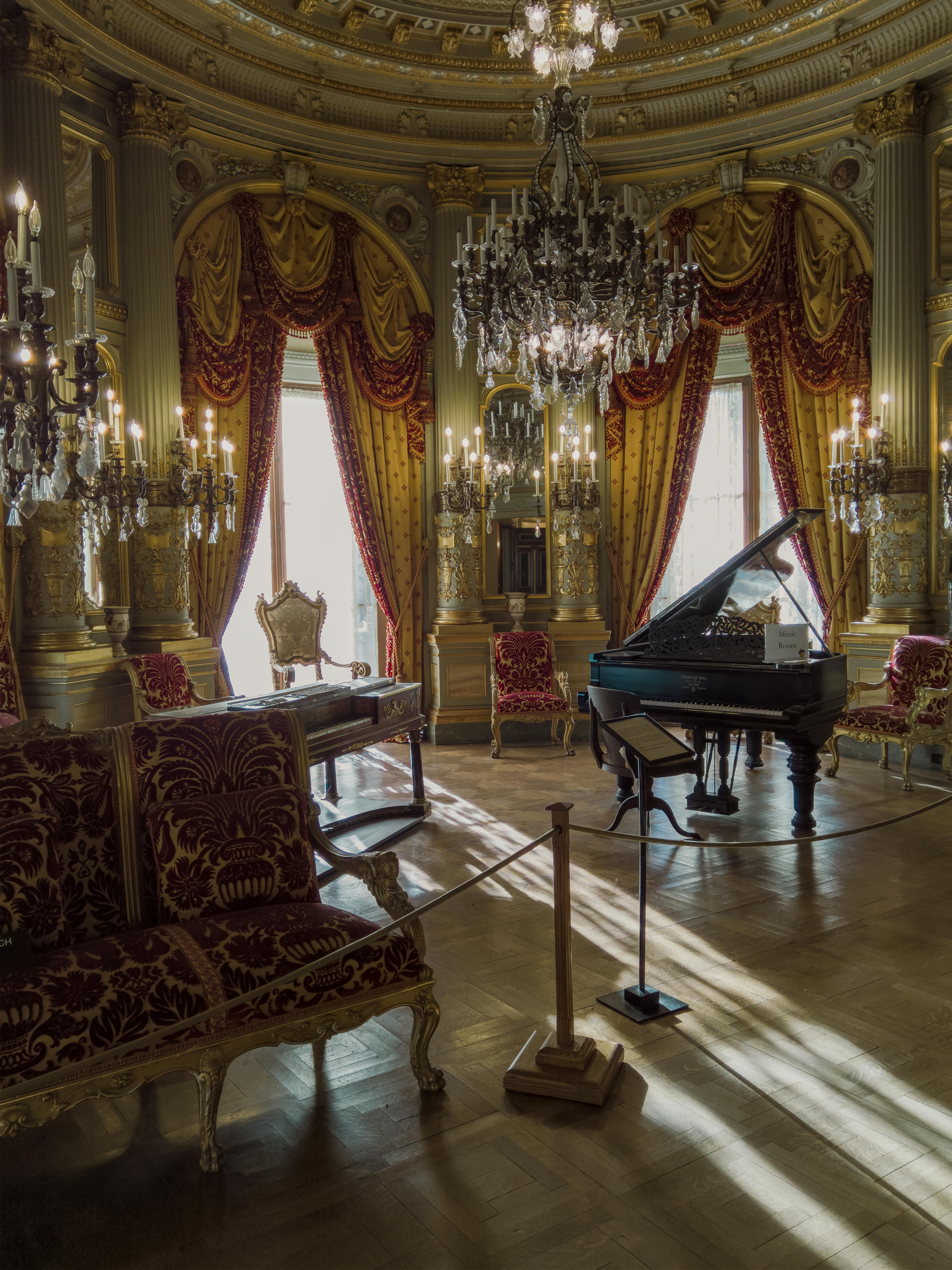 Luxurious interior of a Newport mansion with antique furnishings and a grand piano.