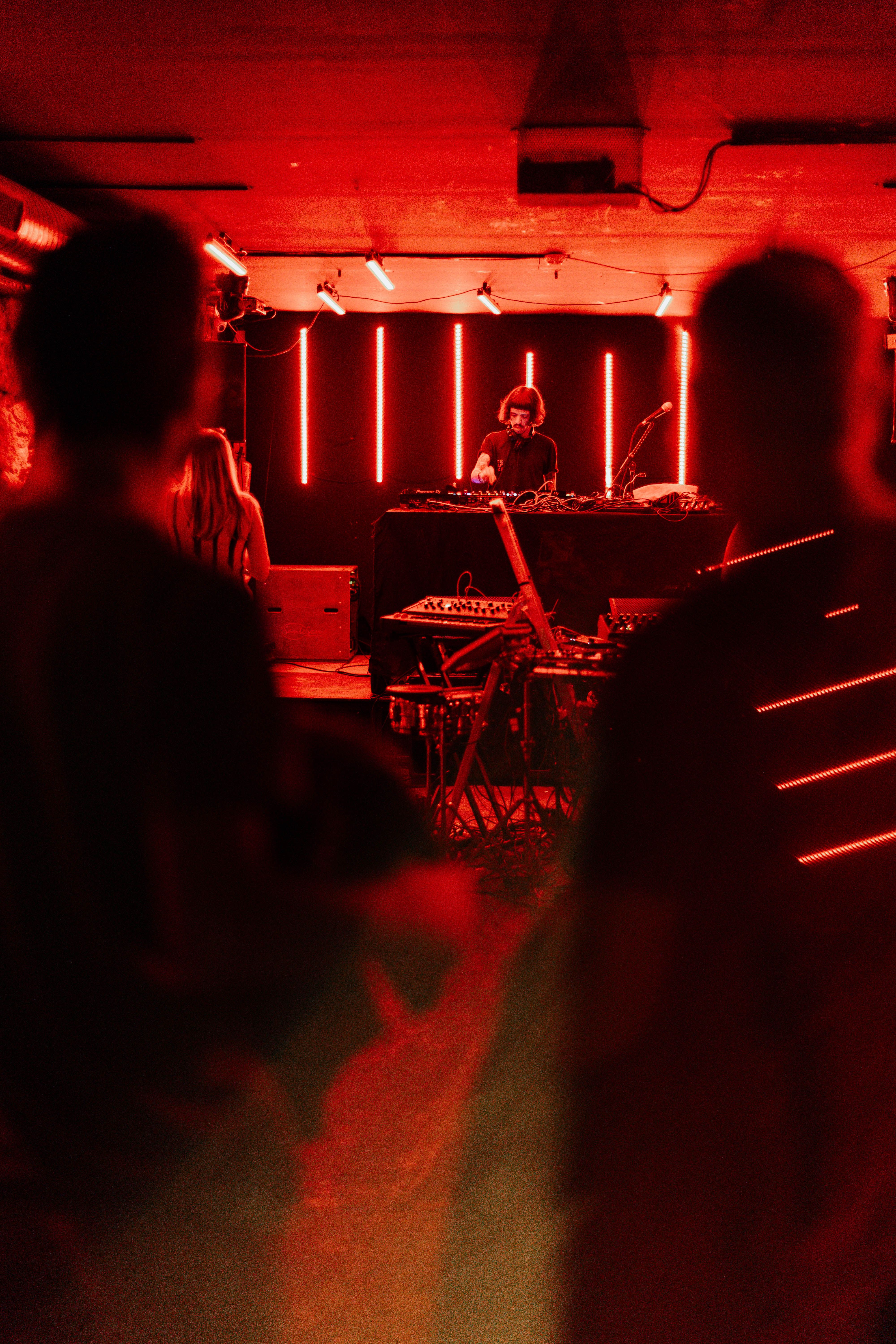 DJ Performing in Vibrant Red Lit Underground Club · Free Stock Photo