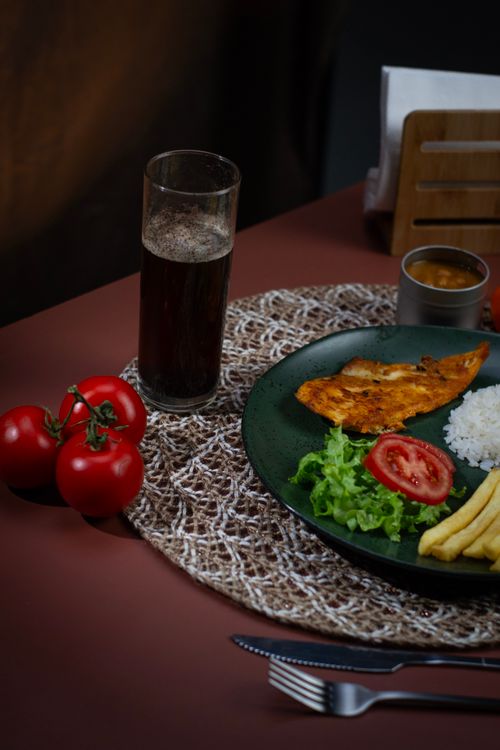 Free A delicious grilled chicken meal with fresh tomatoes, lettuce, rice, and french fries, perfect for lunch. Stock Photo