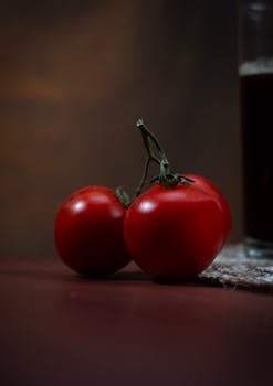 Artistic close-up of fresh red tomatoes on a rustic table with natural lighting, perfect for food and cuisine photography.