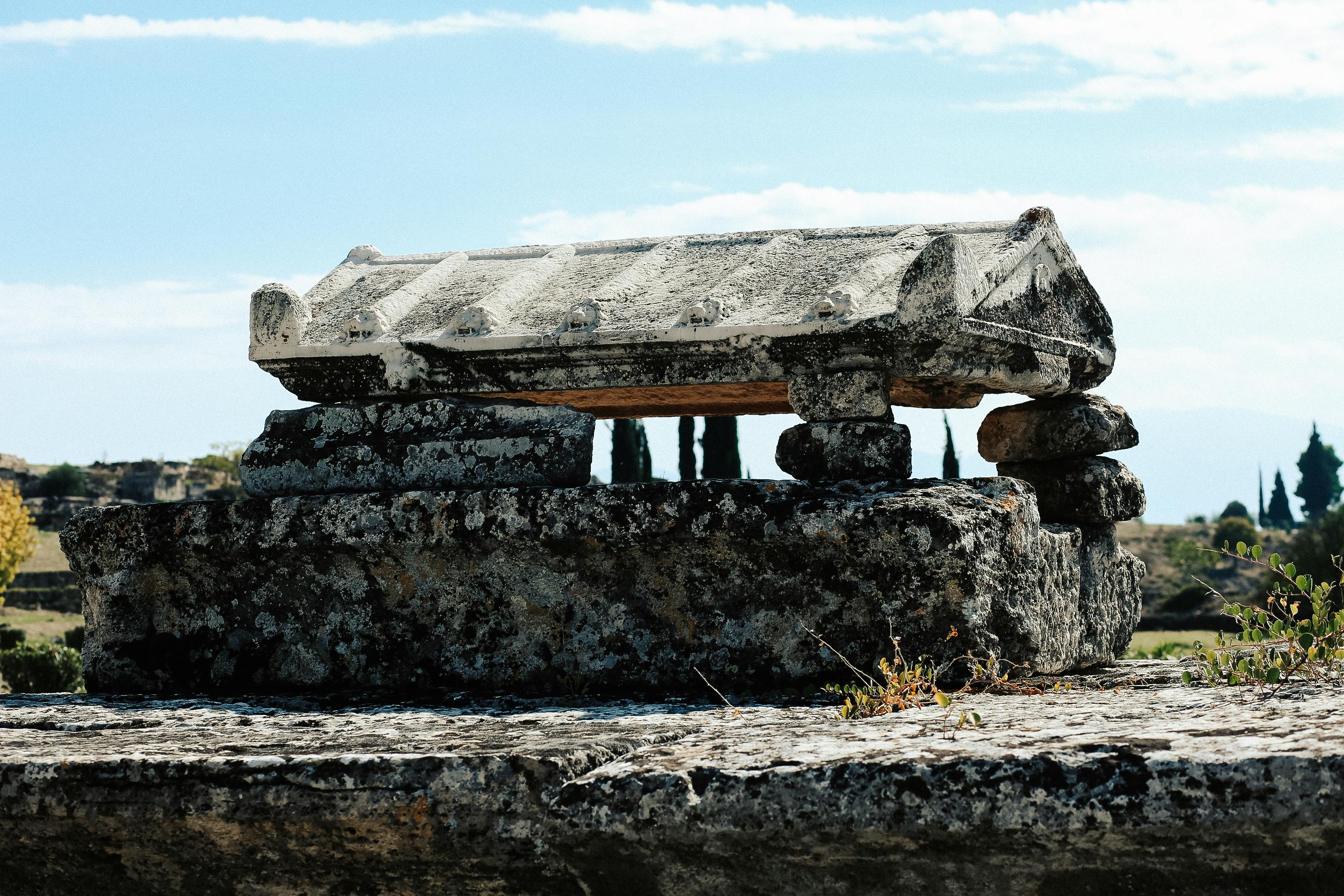 Explore the ancient stone tomb in Hierapolis with its historic stone masonry under clear skies.