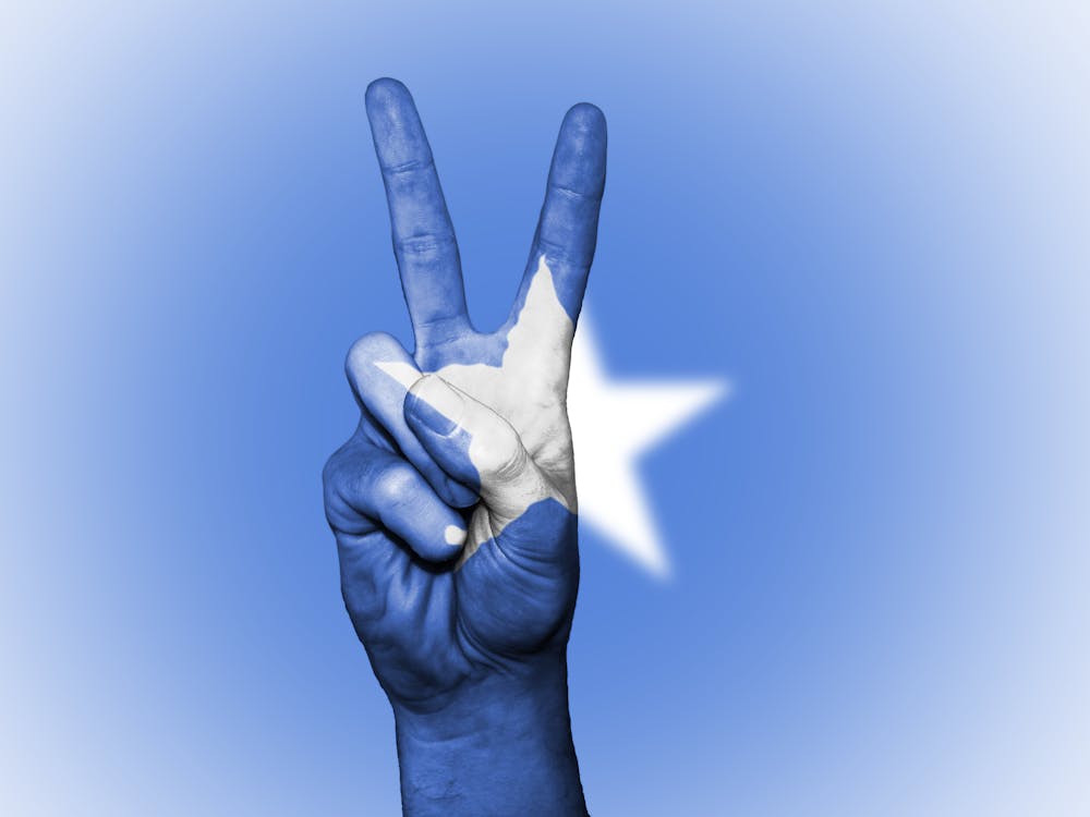 Free Blue and White Star Painted Hand in Peace-sign Gesture Stock Photo