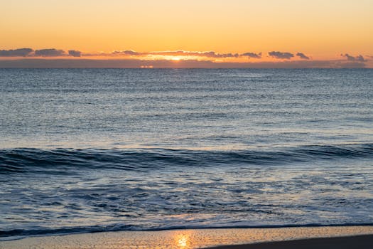 Serene sunset over the Mediterranean Sea with gentle waves in Valencia, Spain.