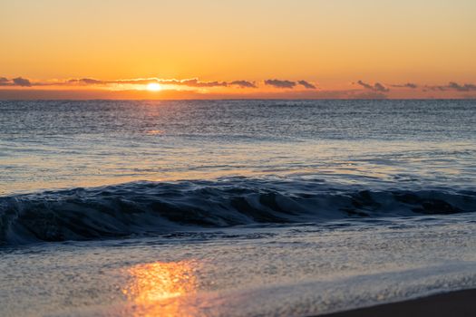 Capture of a serene sunset over the Mediterranean Sea in Valencia, Spain, with tranquil ocean waves.