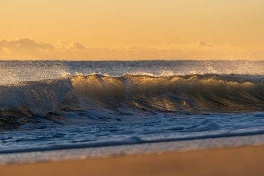 Beautiful waves crashing at sunrise on Valencia beach, capturing the golden glow and tranquil ocean scenery.