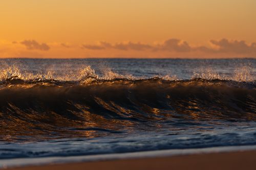 Free Captivating sunset waves crashing on the Valencian coast under a golden sky. Stock Photo