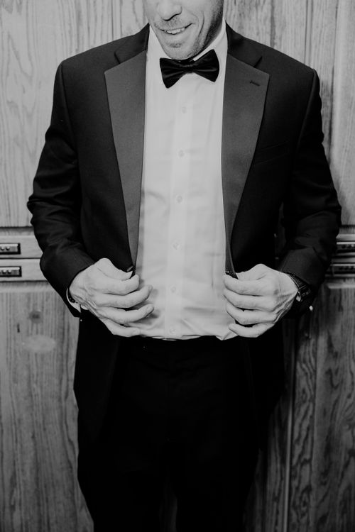 Free A man adjusting his tuxedo, exuding sophistication and elegance. Stock Photo