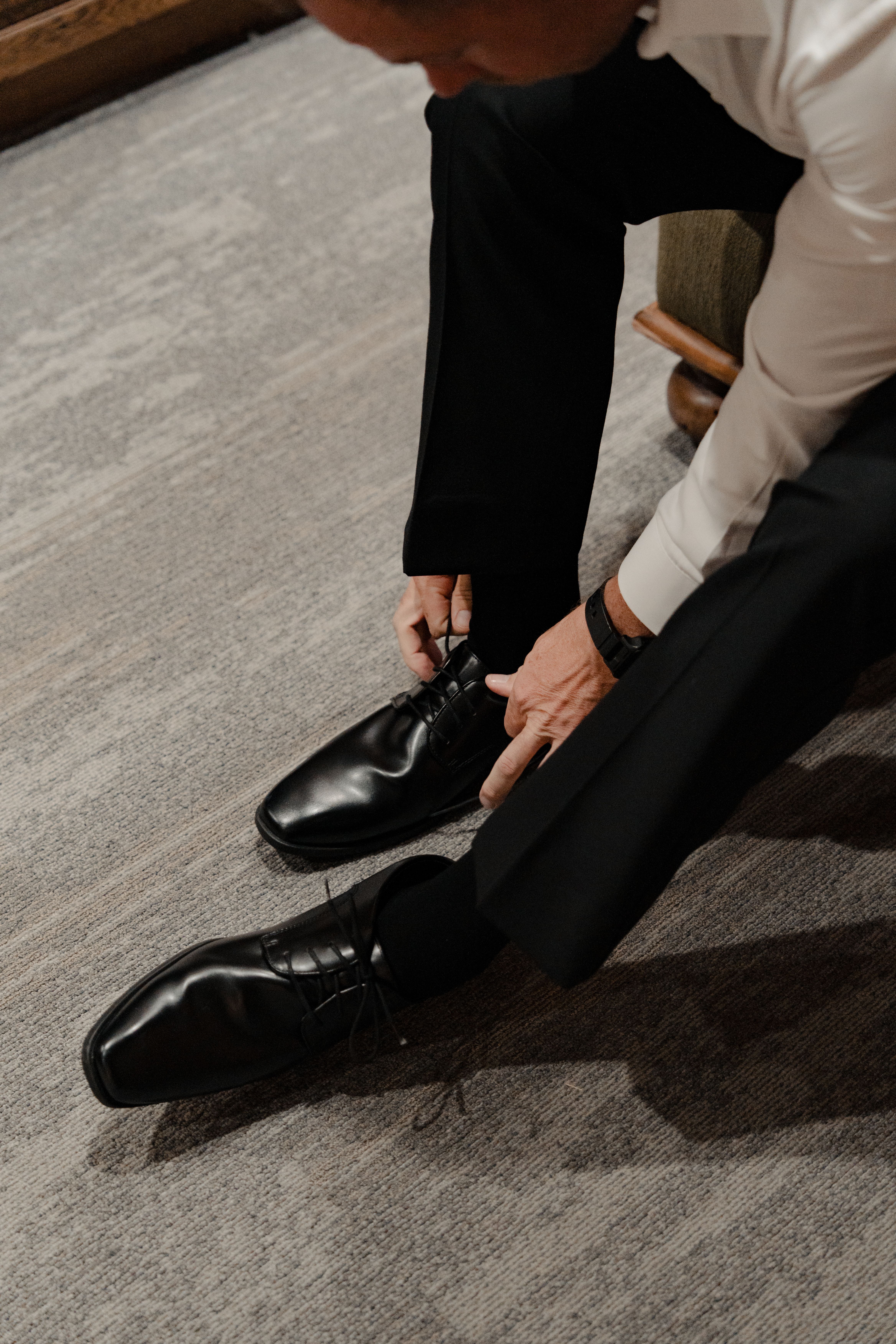Man tying formal black shoes indoors  Free Stock Photo