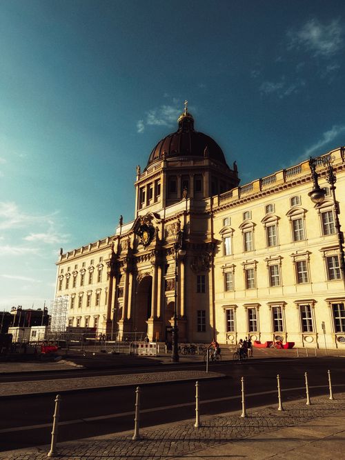 Free A majestic building with classical architecture in Berlin, illuminated by sunlight and a clear blue sky. Stock Photo