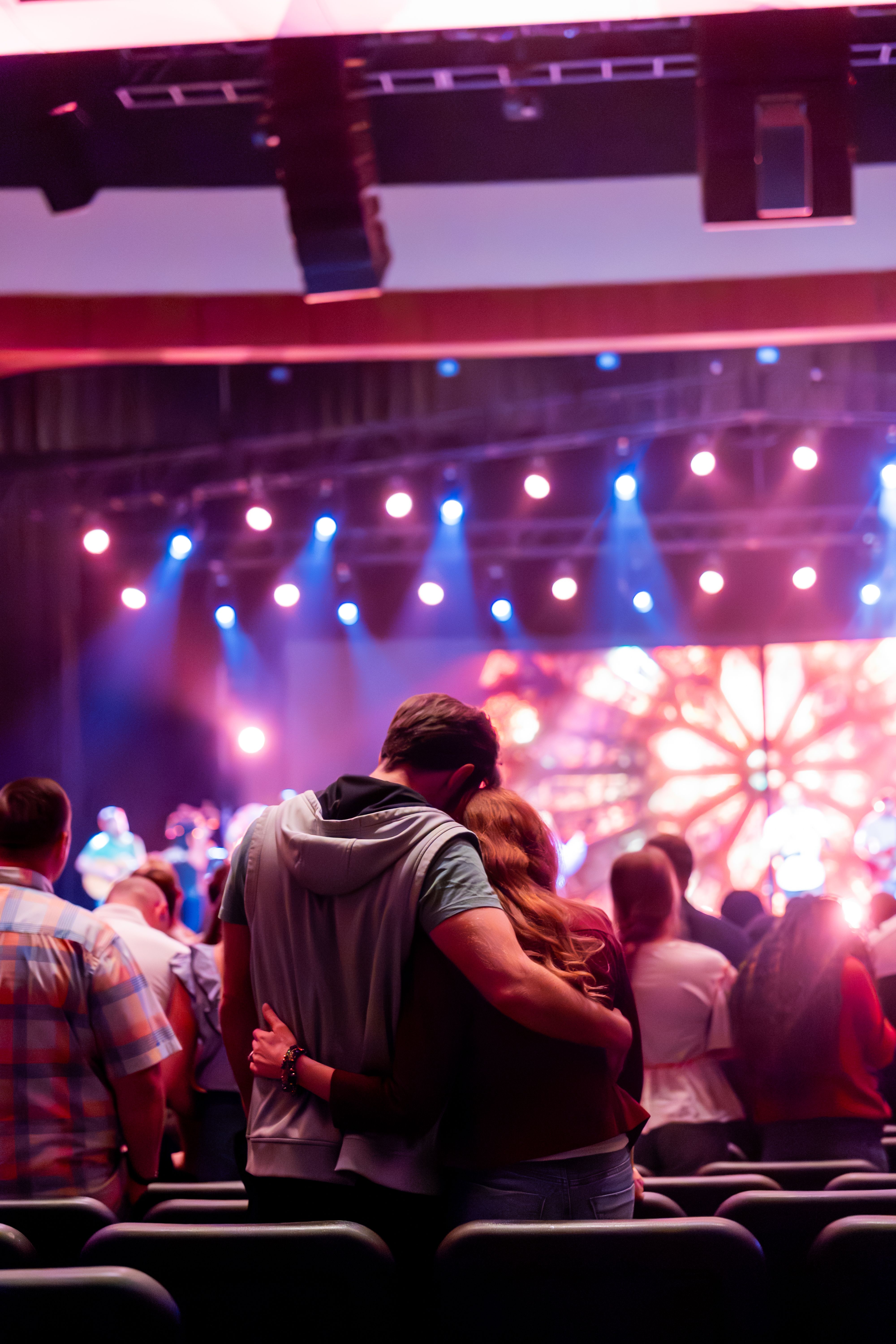 Couple Embracing at Vibrant Music Concert · Free Stock Photo