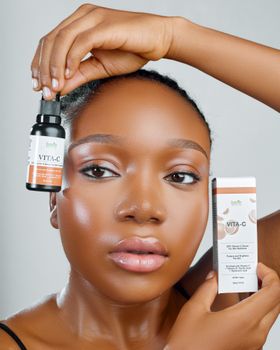 Fresh-faced African model showcasing Vita-C skincare in a studio setting.