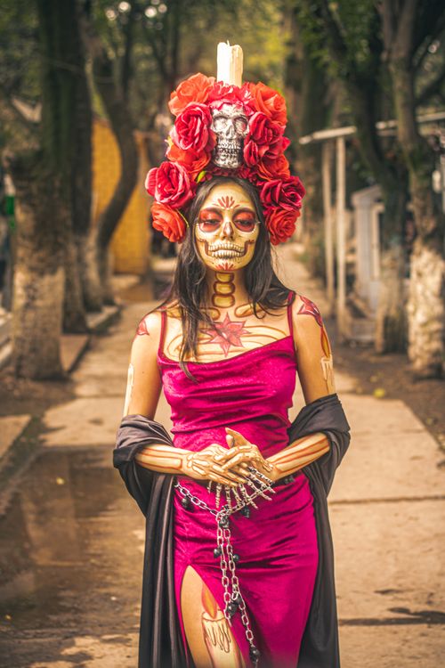 Free Catrina in colorful costume with skull makeup, standing outdoors, celebrating Day of the Dead. Stock Photo