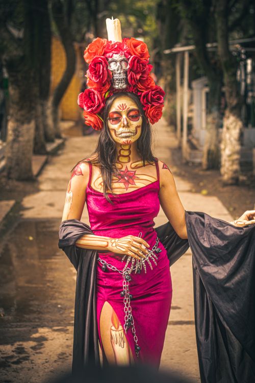 Free Woman in traditional Day of the Dead costume with skull makeup and ornate headdress in a Mexican cemetery. Stock Photo