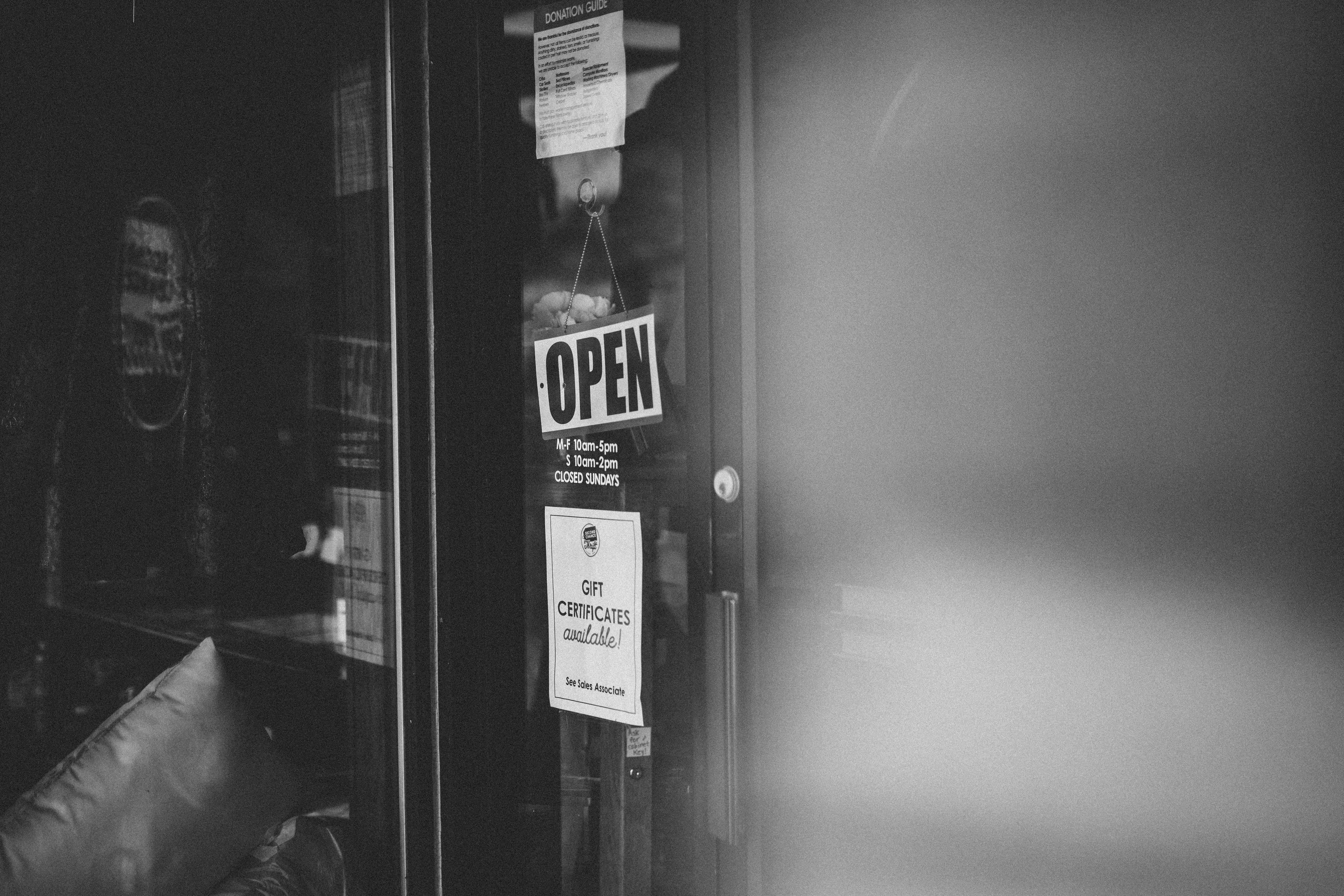Gratis Foto in bianco e nero di un cartello aperto sulla porta di un negozio dell'usato in Minnesota. Foto a disposizione