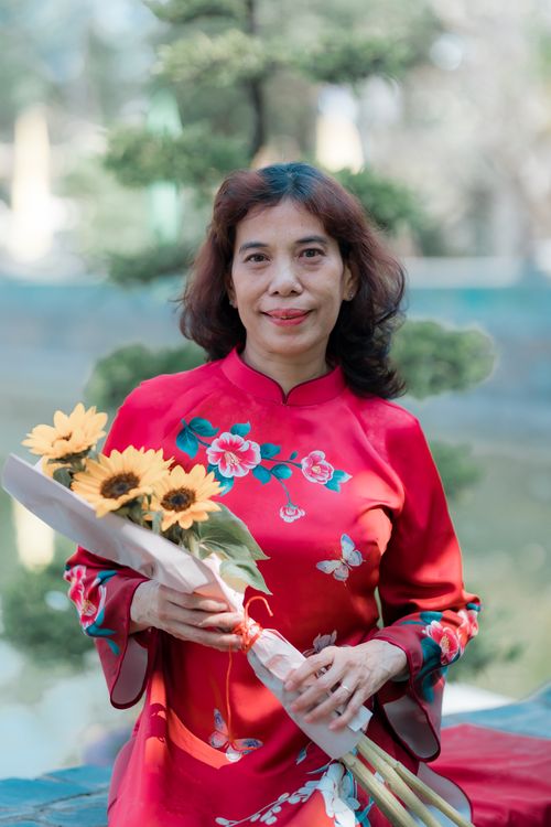 Woman in Red Dress Holding Sunflowers Outdoors · Free Stock Photo