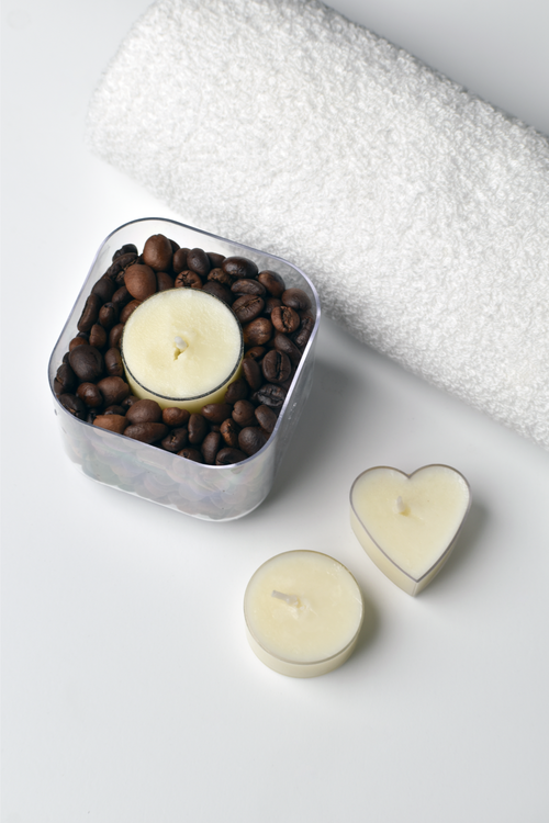 Free A tranquil spa arrangement with candles, coffee beans, and a towel for relaxation. Stock Photo