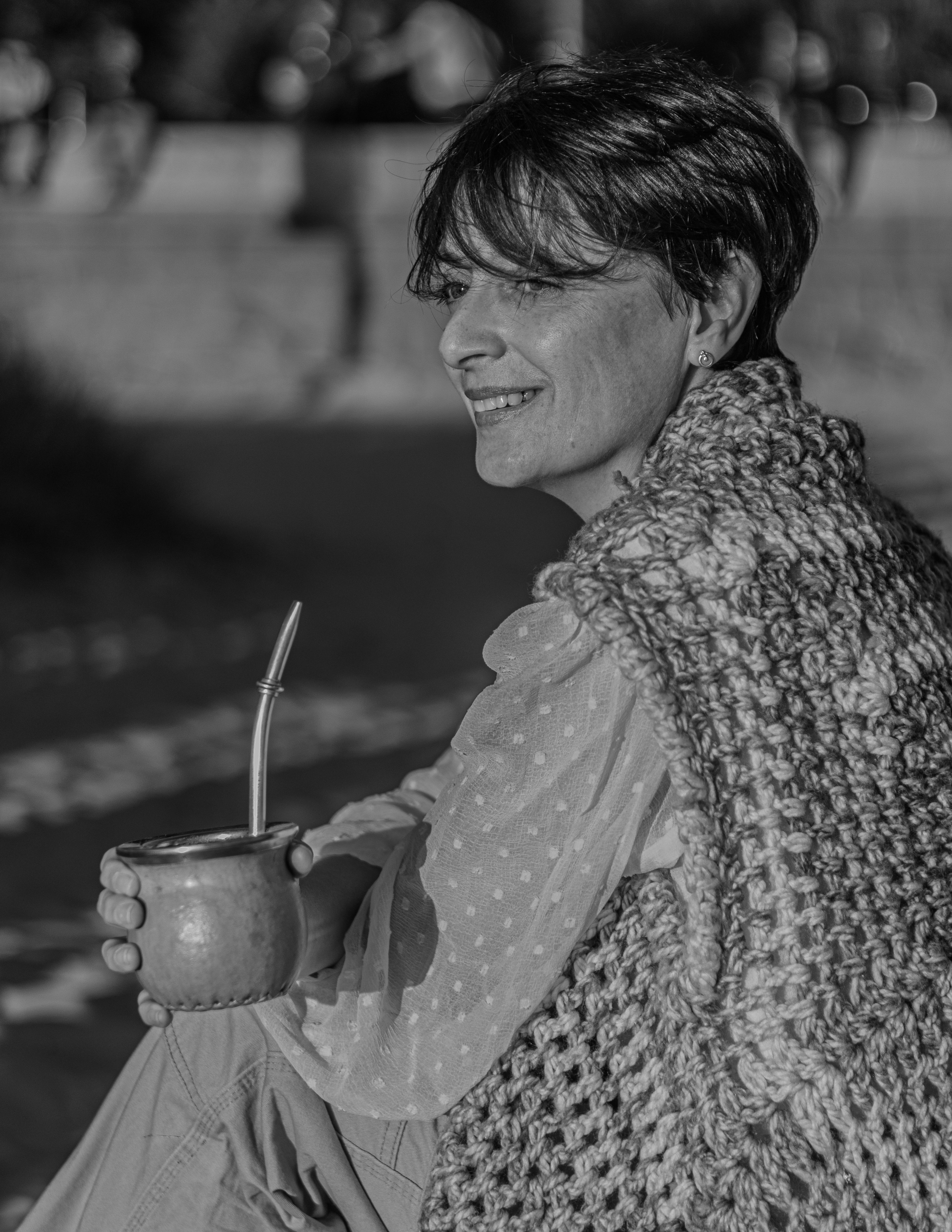 A woman relaxing outdoors with yerba mate in Montevideo, Uruguay, enjoying a sunny day.