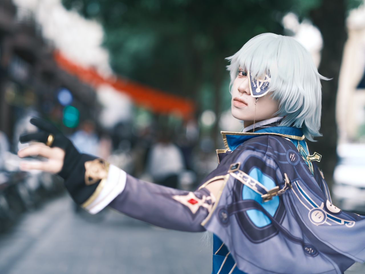 cosplayer poses in a detailed fantasy costume on a busy street creatin
