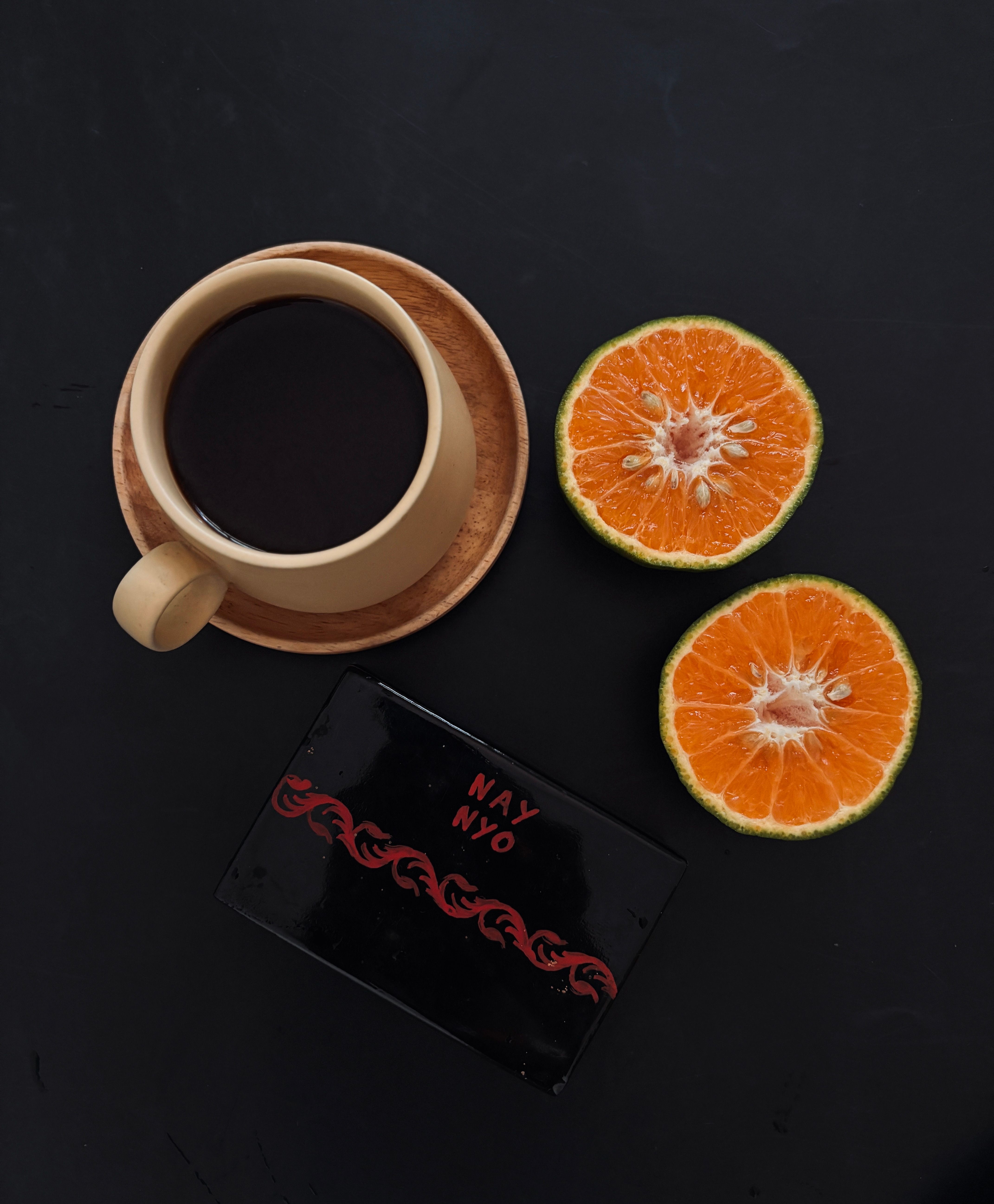 Flat Lay of Coffee with Oranges on Dark Surface