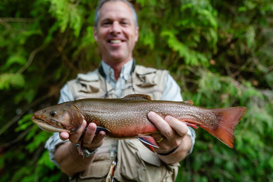 An angler holding a large brook trout, showcasing a successful fishing trip in Ontario.