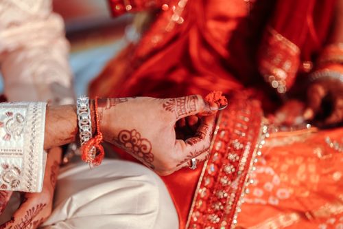 Free Close-up of hands during an Indian wedding ceremony with intricate henna designs. Stock Photo