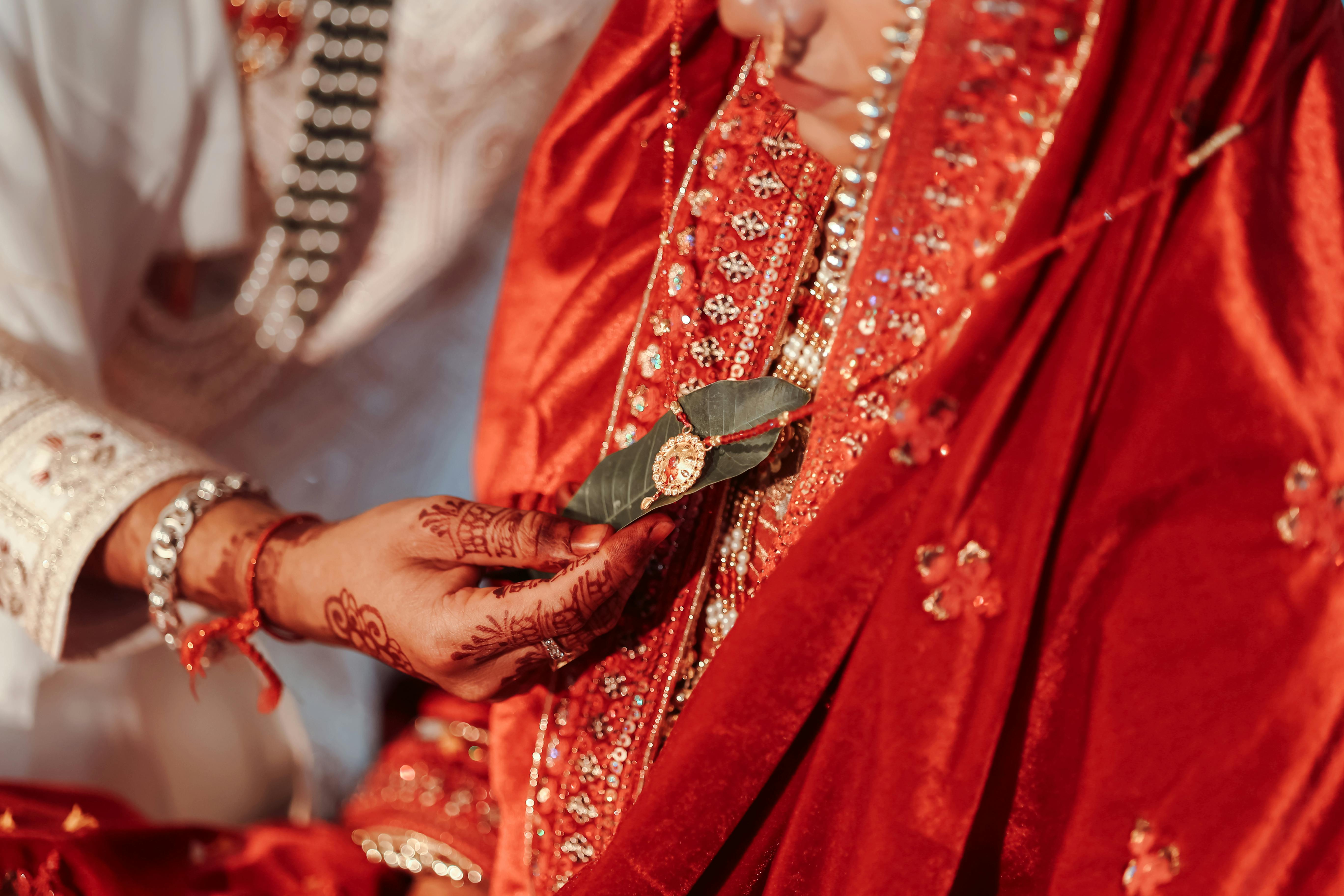 Close-up of a ceremonial ritual during a traditional Indian wedding in vibrant attire.